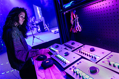 One of the worship team’s vocalists steps offstage to make a quick adjustment to her personal binaural mix